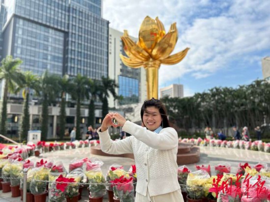 來(lái)自廣東的游客對(duì)著盛世蓮花雕塑“比心”，她說(shuō)“比心”是因?yàn)橄胍磉_(dá)自己“愛祖國(guó)、愛澳門”的心情。中青報(bào)·中青網(wǎng)記者 寧迪/攝